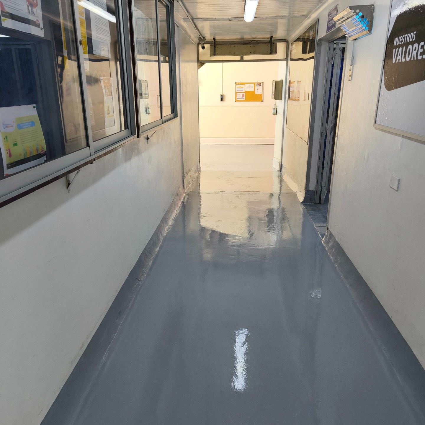 Pasillo interior con piso gris revestido, trabajo de MAKADI
